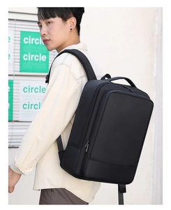 Hombre con mochila negra expandible para portátil de negocios en una toma exterior