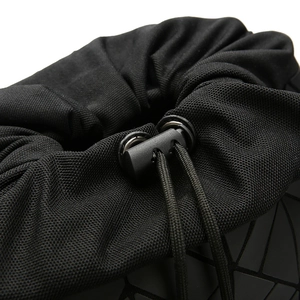 Macro view of geometric pattern panel and drawstring closure on black commuter backpack