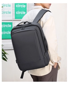 Vista lateral de una mochila de negocios gris de gran capacidad con correas anchas de viaje