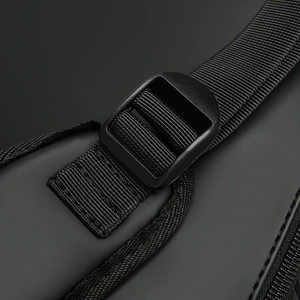 Macro detail of the durable plastic buckle and nylon strap on a waterproof black backpack