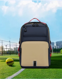 Detail view of a large navy blue commute backpack on a soccer field grass background