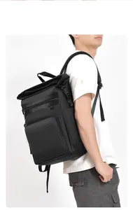 Side view of black waterproof picnic backpack with roll-top closure on male model