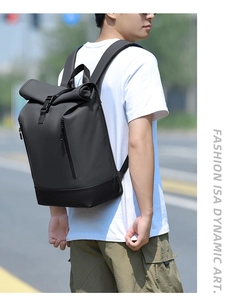 Outdoor shot of minimalist roll-top laptop backpack with adjustable buckle on male model