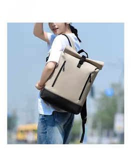 Detail of roll-top backpack with beige and black waterproof panels and buckle closure