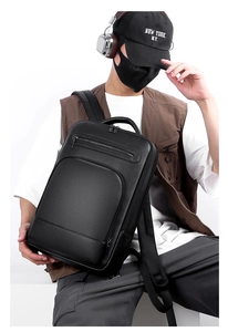 Detailed side view of black lychee grain PU leather backpack worn on a casual male model
