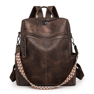 Detail of dark brown vintage faux leather backpack with woven strap and contrast stitching
