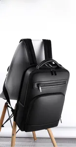 Close-up of three-dimensional black PU leather business backpack on minimalist chair
