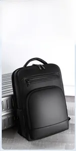 Close-up of black PU leather business backpack with silver metal zippers on a suitcase