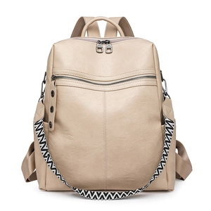 Detailed close-up of a beige fashion backpack with textured leather and geometric strap