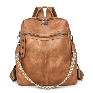 Close-up of brown PU leather backpack with woven strap and textured stitching details