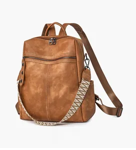 Detail of vintage brown leather backpack showing texture and ethnic woven strap