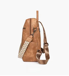 Close-up of brown PU leather backpack side with woven print wide strap and zipper pocket