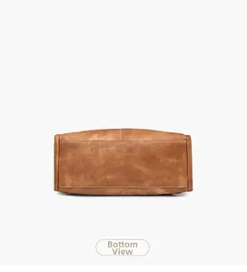Detailed bottom view of the brown vintage backpack showing stitching and flat base