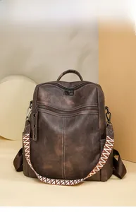 Detail view of dark brown vintage PU backpack featuring textured material and woven side straps