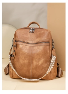 Detail of a brown PU leather backpack with vintage texture and jacquard woven strap