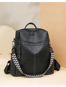 Detail of black faux leather backpack with three zipper pockets and striped woven strap