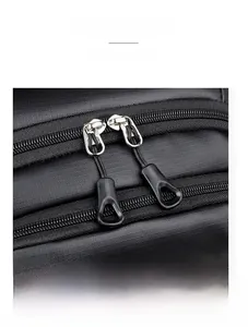 Detail shot of premium dual metal zippers on a black water-resistant backpack