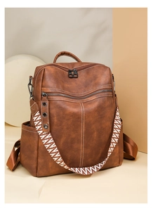 Detail view of brown faux leather backpack with stylish geometric patterned strap