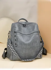 Detail of grey PU leather backpack with vintage texture and stylish geometric strap