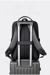 Detailed back view of a black travel backpack featuring a luggage strap for suitcase handles