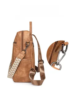 Detail view of vintage brown leather backpack with detachable strap and metal hardware