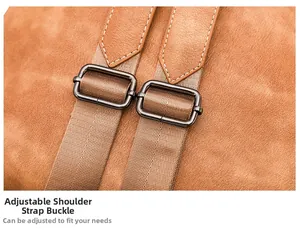 Detail view of the adjustable brown suede backpack strap with metallic buckle