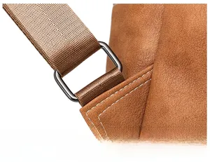 Close-up of brown frosted backpack strap connector with grey metal buckle and white stitching