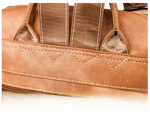 Detail of reinforced triangle stitching on brown faux leather backpack straps