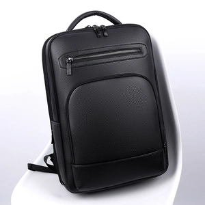 Business black PU leather backpack with litchi texture on a white chair