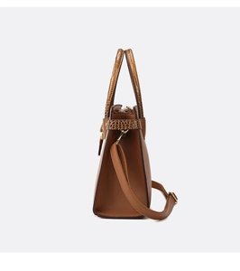 Vista laterale dettagliata della borsa tote marrone con texture miste e cuciture