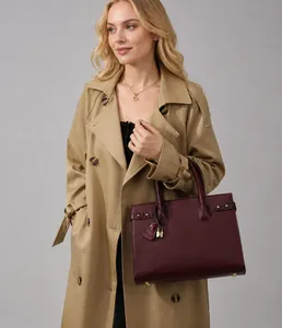 Borsa tote bordeaux con motivo litchi abbinata a un classico trench color cammello