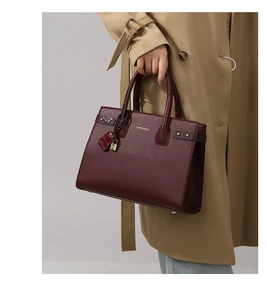 Dettaglio borsa shopper bordeaux in pelle martellata con eleganti finiture dorate lucide