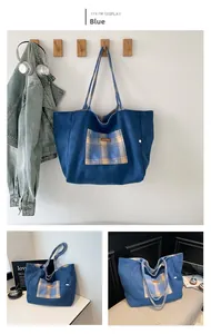 Detailed close-up of blue canvas tote bag featuring tartan plaid pockets and logo detail