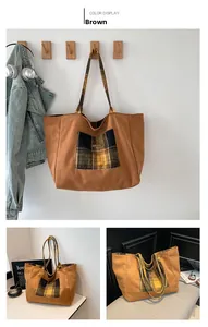 Detail of wool plaid pocket and shoulder straps on a large tan tote bag in college style