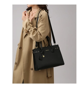 Dettaglio borsa tote in pelle nera con finiture dorate e tracolla rimovibile