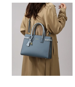 Borsa tote in pelle blu nebbia abbinata a un trench kaki, vista posteriore di moda