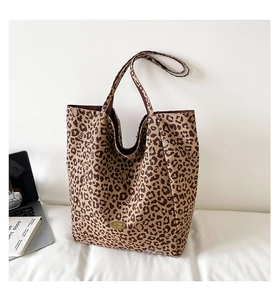 Detail of leopard print tote bag with hidden cat silhouettes and handmade metal plaque