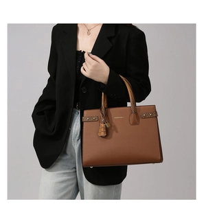 Dettaglio borsa tote in pelle caramello con manico texture coccodrillo e logo oro
