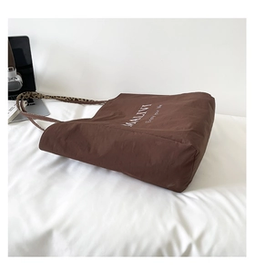 Close-up of brown tote bag with leopard print straps and white letter print