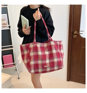 Detailed macro view of British style plaid wool tote bag with premium leather logo patch