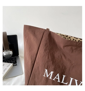 Close-up of brown nylon tote bag with MALIV logo and stylish leopard print lining