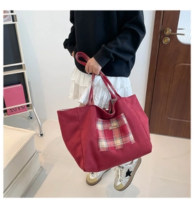 Detail view of red canvas tote bag with plaid pocket and durable double handles