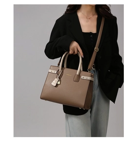 Dettaglio della borsa in ecopelle marrone con manici beige stampa cocco e lucchetto oro