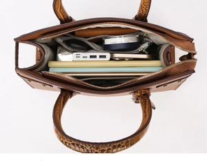 Vista dall'alto dell'interno spazioso della borsa tote marrone con scomparti e oggetti comuni