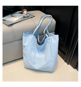 Detail of the blue tote bag showing the interior animal print lining and wide shoulder strap