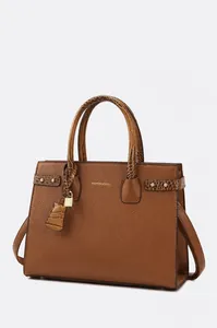 Dettaglio della borsa in pelle marrone con motivo litchi, lucchetto dorato e trama goffrata