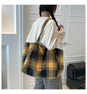 Detailed view of British style yellow plaid tote bag showing texture and leather label