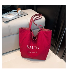Detail of red tote bag with leopard print lining and white MALIVI text on fabric