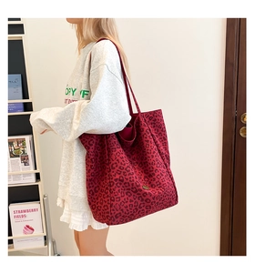 Detail view of large red leopard print canvas tote bag with magnetic snap and interior space