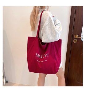 Detail of burgundy canvas tote bag featuring MALIVI text and Enjoy your life slogan